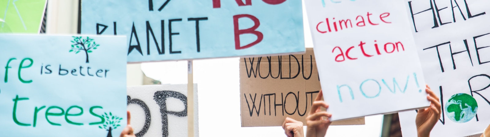 People holding signs at a climate rally.